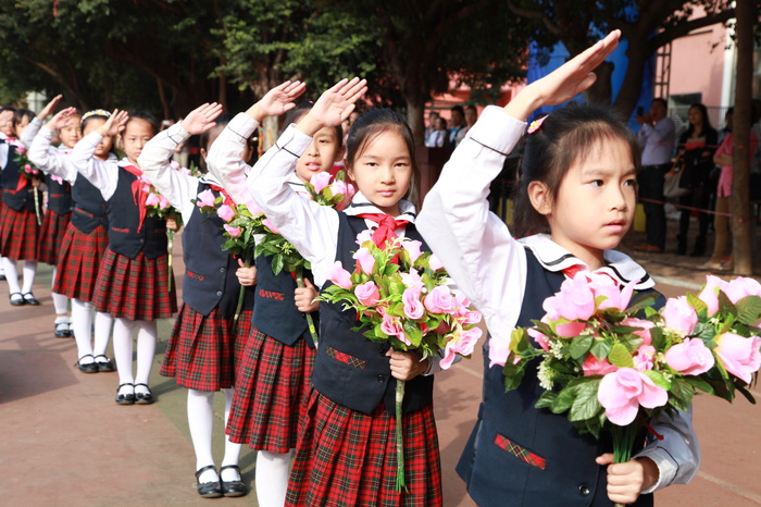 04、圖為鮮花隊(duì)的同學(xué)在升國旗儀式時(shí)向國旗敬禮